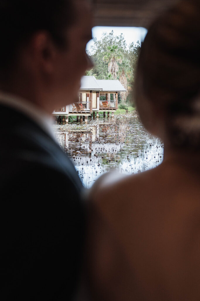 Married couple on their wedding day enjoying the view of the lake at Leaves and Fishes