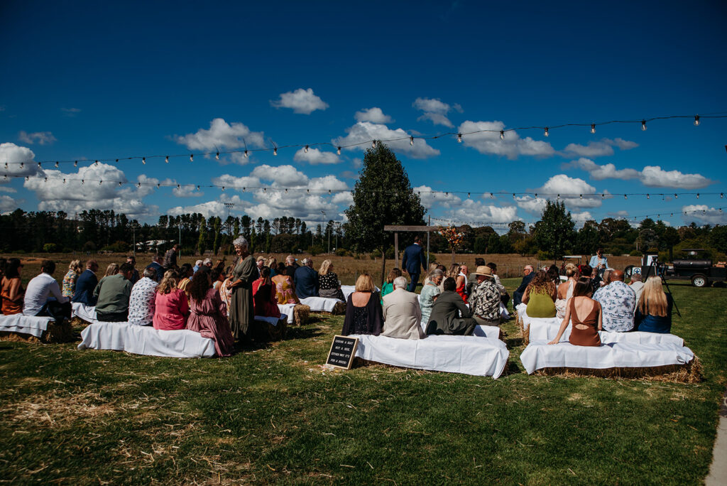 Wedding guests sitting on blaes of hay at Great Hops Brewery