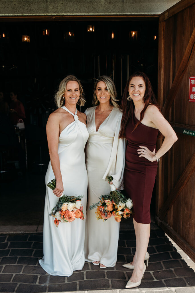 Brides Christie and Hanah posing with their celebrant Julie Muir after their wedding ceremony at Great Hops Brewery