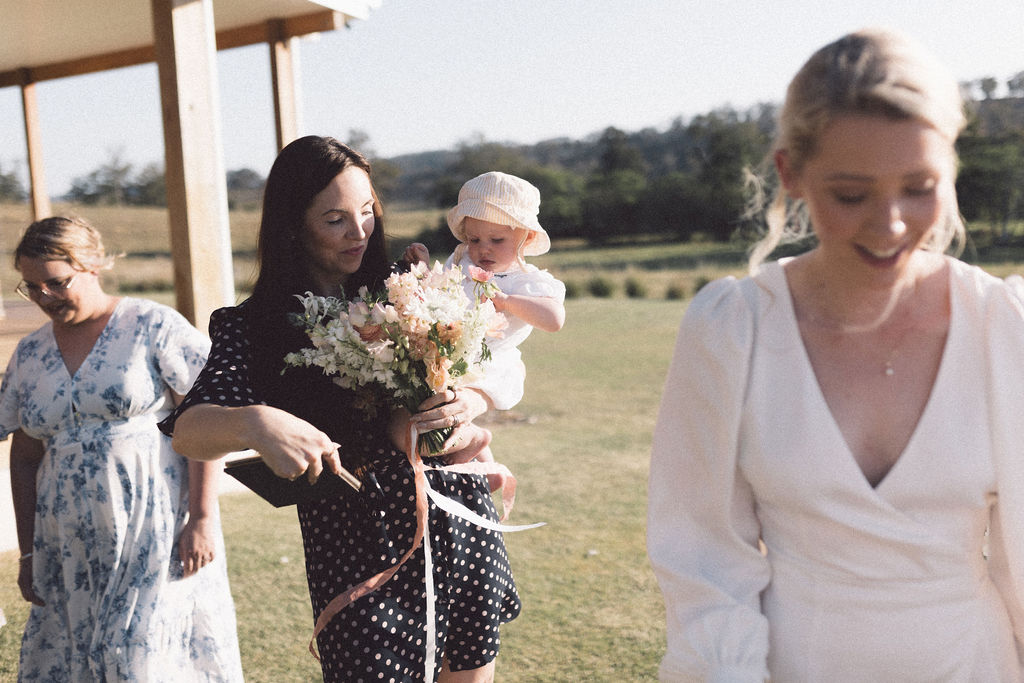 Celebrant holding the baby during the elopement of her parents at Wallaringa Farm