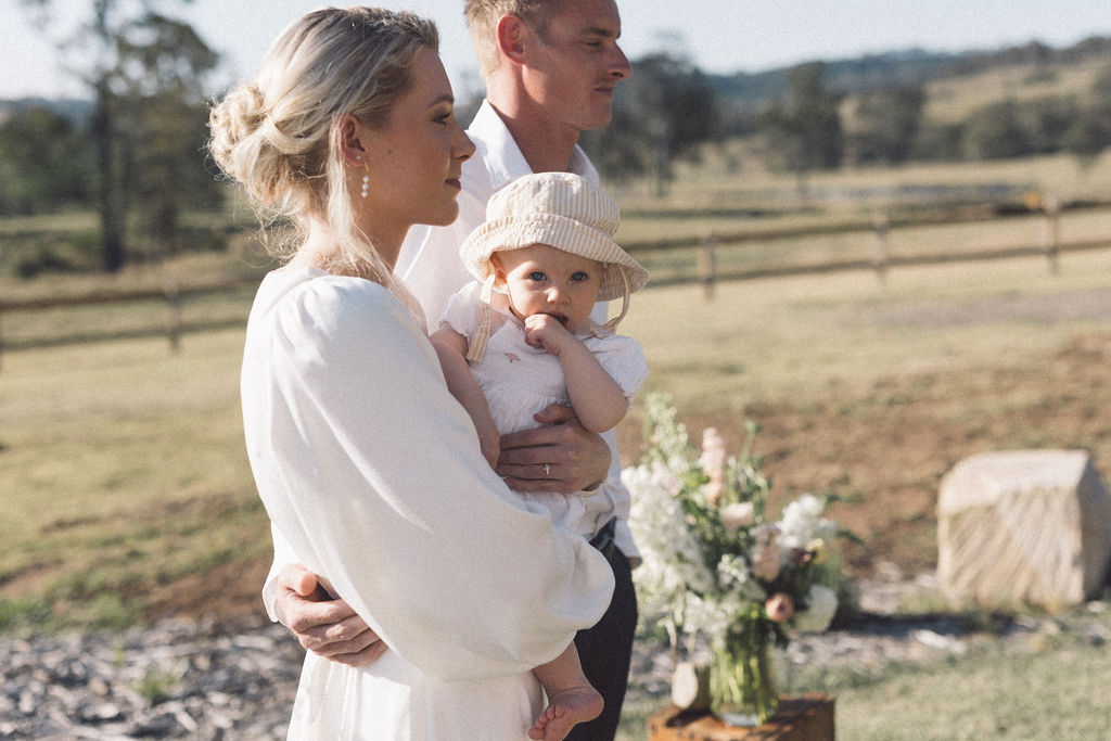 baby with sun hat on being held my her mother during her wedding at Wallaringa Farm