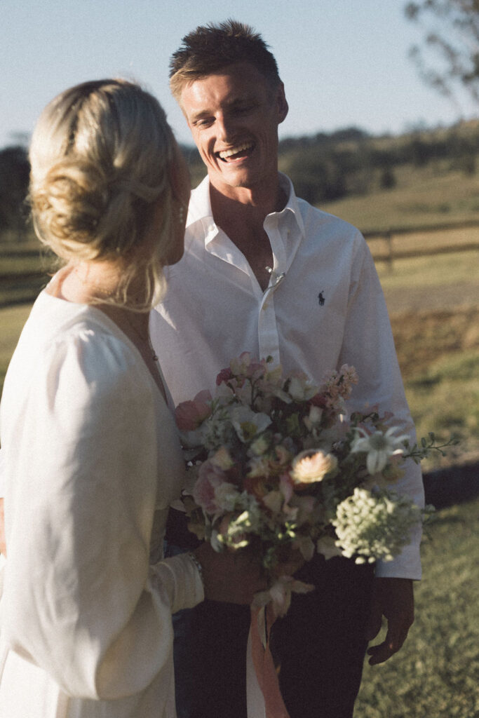 Bride and groom smiling at each other mid ceremony at Wallaringa Farm