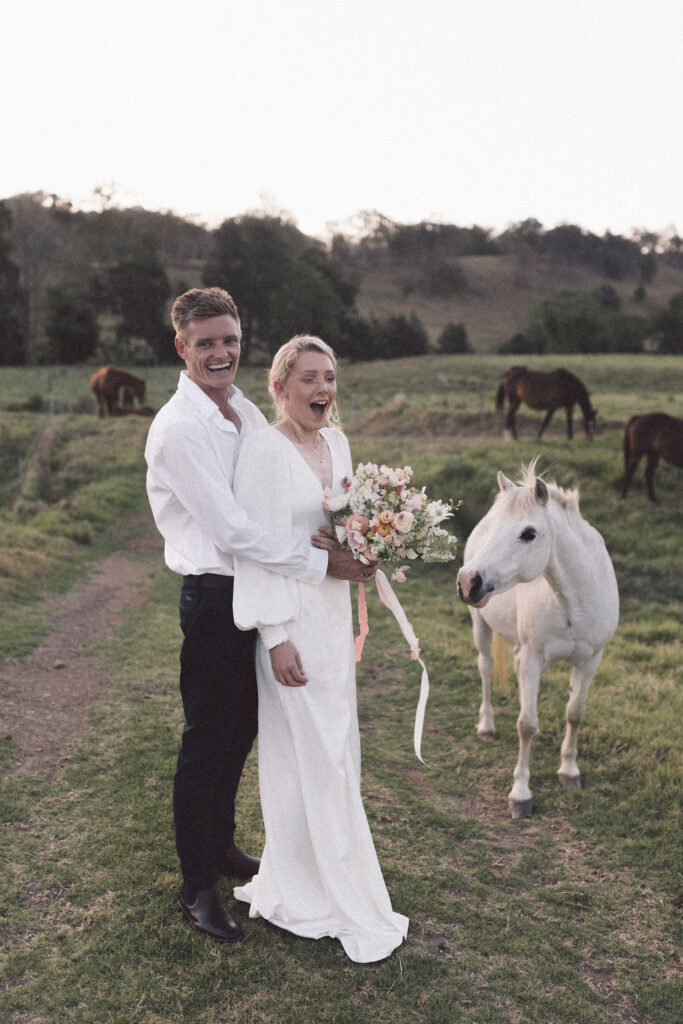 Newlyweds having fun with the horse after their nuptials