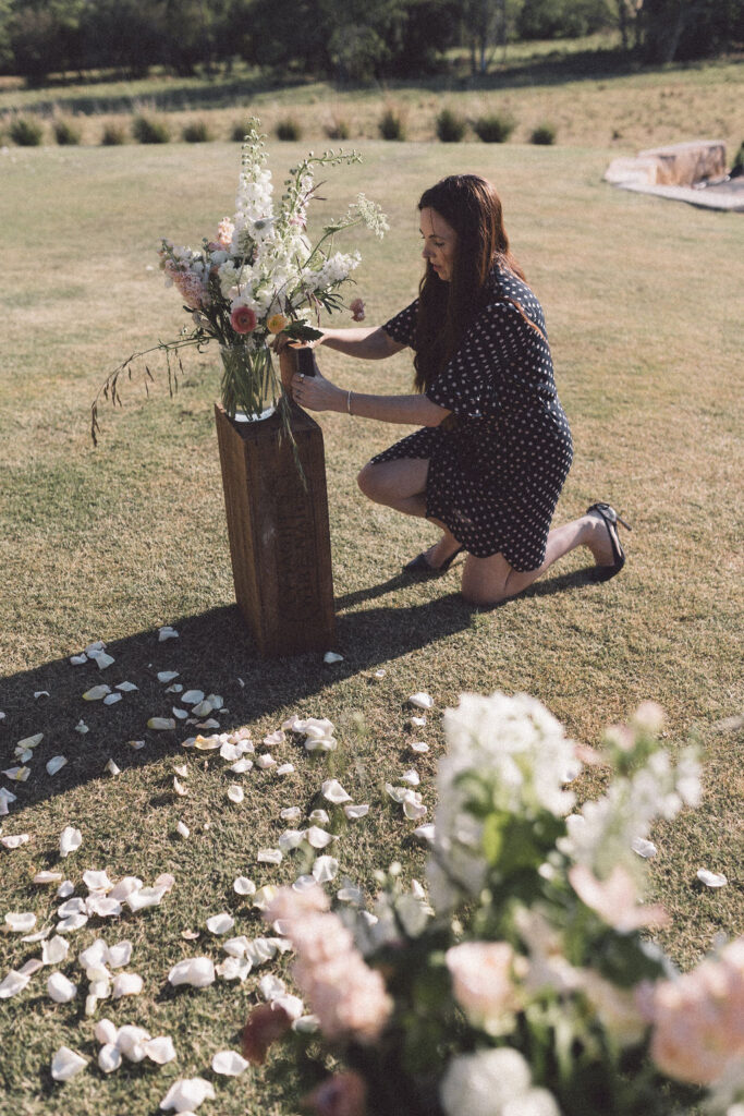 Celebrant Julie Muir fixing the flowers at the ceremony spot at Wallaringa Farm