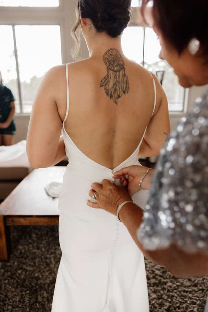 Dreamcatcher tattoo on brides back with low cut wedding dress