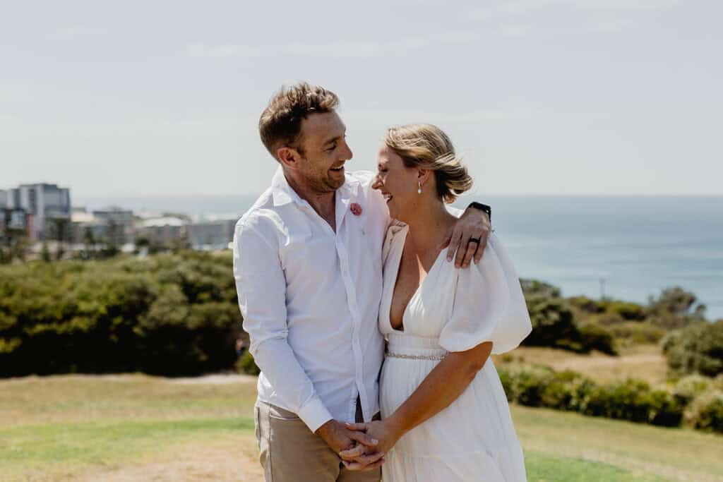 Couple laughing during their  Newcastle coastal wedding