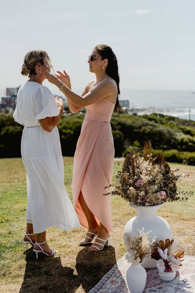 Bridesmaid fixing bride's makeup for  Newcastle coastal wedding