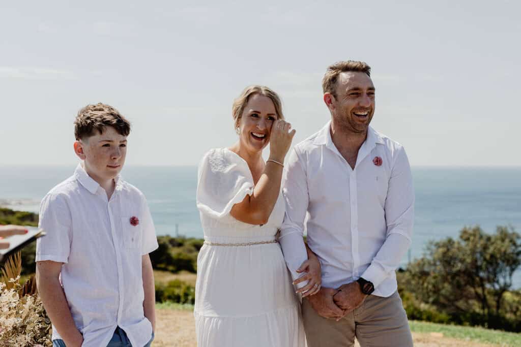 Bride wiping a tear from her face during  Newcastle coastal wedding