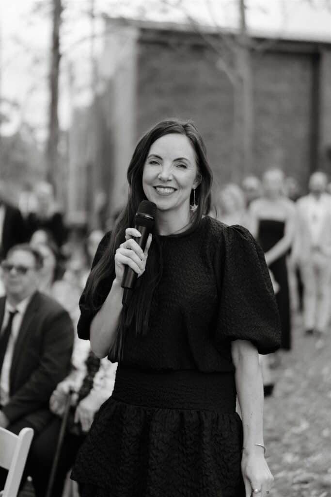 Celebrant Julie Muir holding a microphone at The Wine House