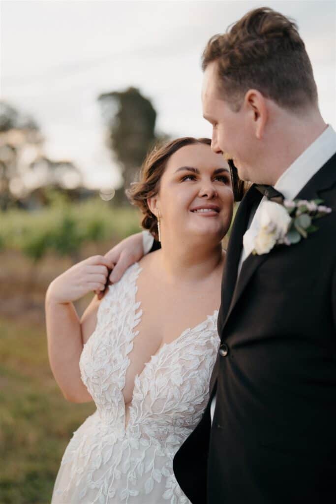 Gorgeous bride in incredible dress staring into husbands eyes at The Wine House