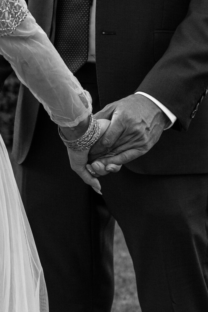 couple holding hands during wedding ceremony.