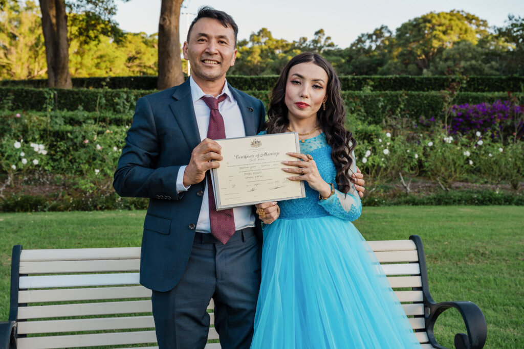 Couple hold up signed marriage cert after Jesmond Park wedding