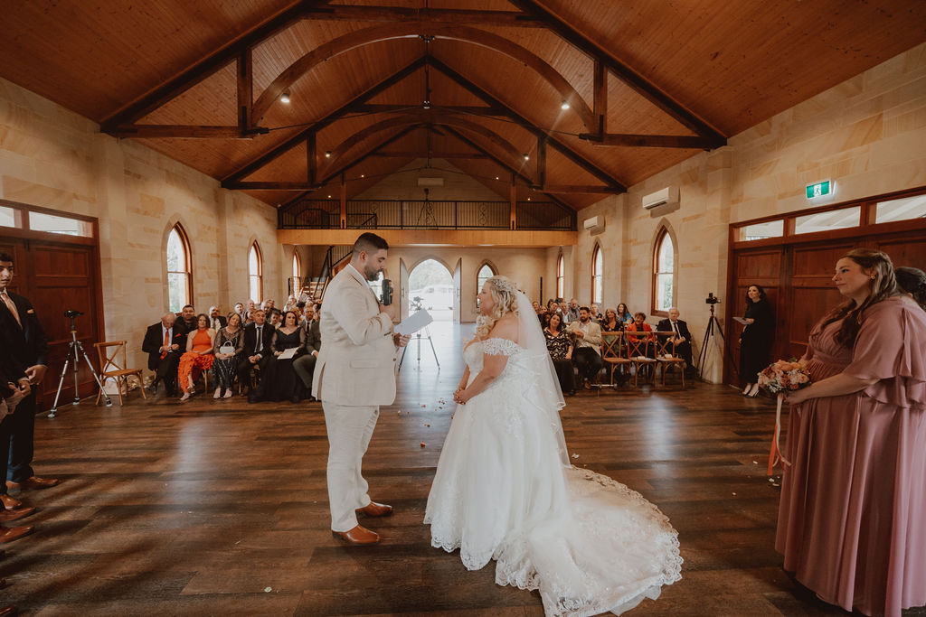 groom-reading-his-vows-to-his-bride-rachel-and-nick-macedonian-wedding-co-hosted-by-julie-muir-at-the-peterson-house-in-hunter-valley-australia