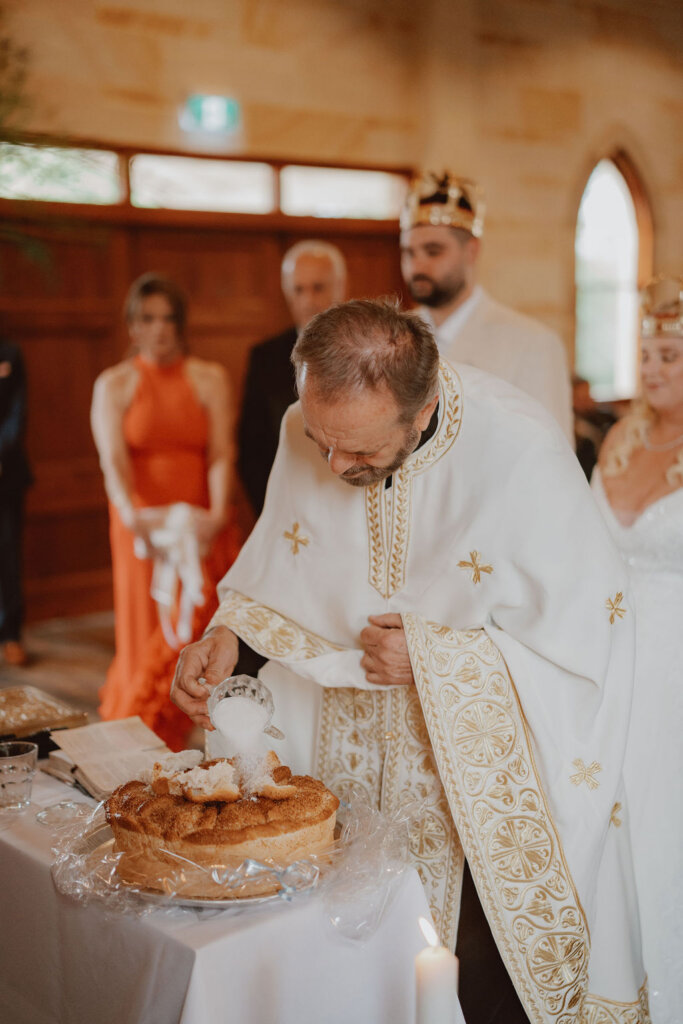 priest-blessing-food-at-the-altar-during-rachel-and-nick-macedonian-wedding-co-hosted-by-julie-muir-at-the-peterson-house-in-hunter-valley-australia