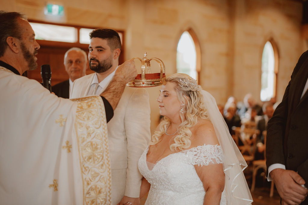 priest-crowning-bride-during-rachel-and-nick-macedonian-wedding-co-hosted-by-julie-muir-at-the-peterson-house-in-hunter-valley-australia