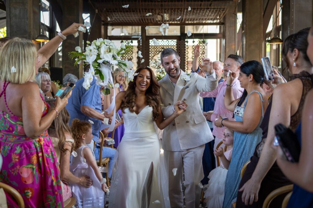 bride-and-groom-getting-showered-by-flower-petal-confetti-during-their-wedding-in-thailand-after-their-coogee-beach-wedding